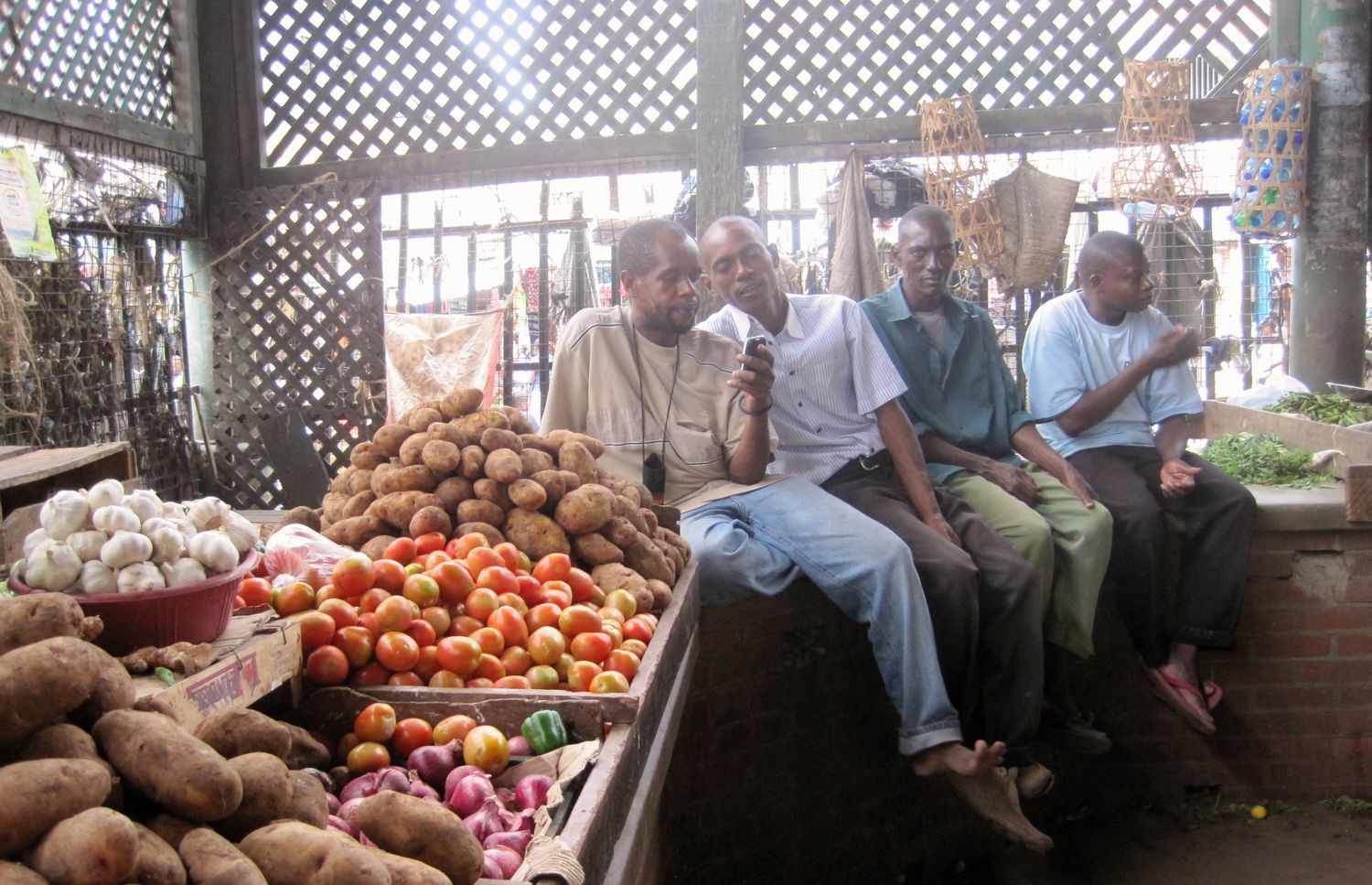 guys with cell phones sitting on corner momba