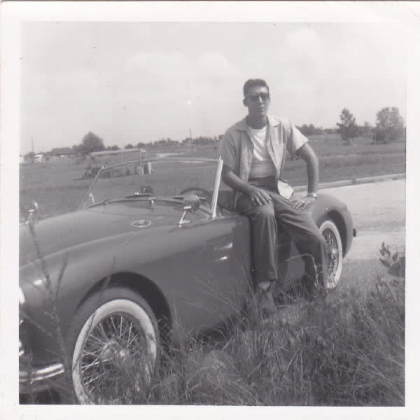 My father poses with the first car he ever bought, circa late 1950's.